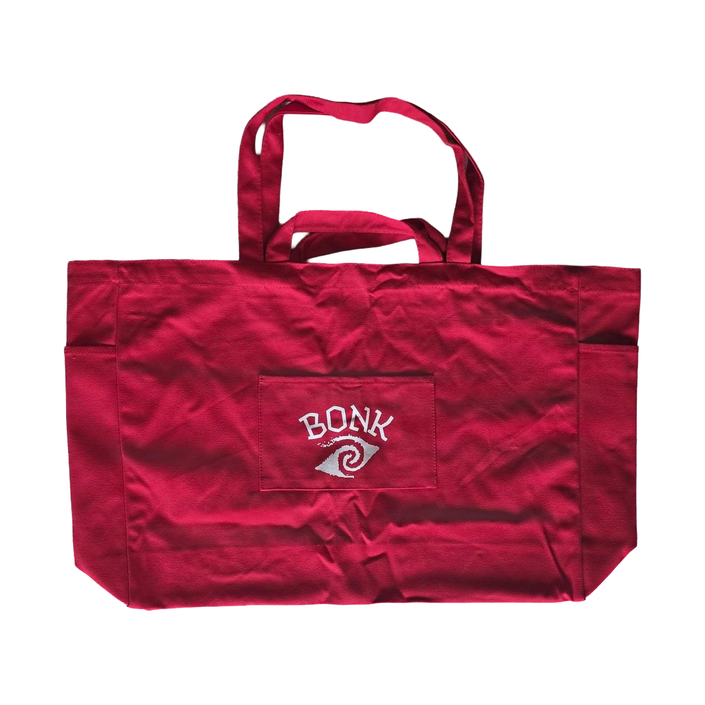 Bonk Canvas Tote in red, back, showing the front pocket and small BONK logo